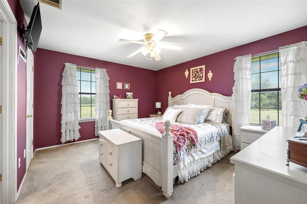 482 Prince Lane Fate, TX 75087 - Photo 18 of 32 a bedroom with a bed and a chandelier