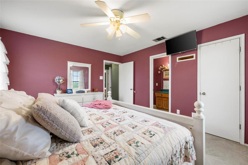 482 Prince Lane Fate, TX 75087 - Photo 19 of 32 a bedroom with a bed and a chandelier