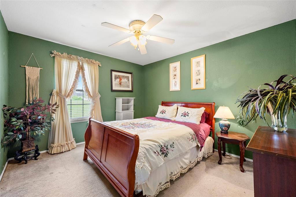 482 Prince Lane Fate, TX 75087 - Photo 23 of 32 a bedroom with a bed and a chandelier