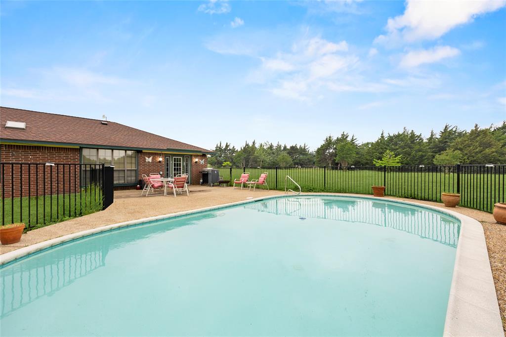 482 Prince Lane Fate, TX 75087 - Photo 29 of 32 a view of swimming pool with a patio and a garden
