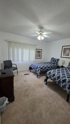 a spacious bedroom with a bed and a chandelier