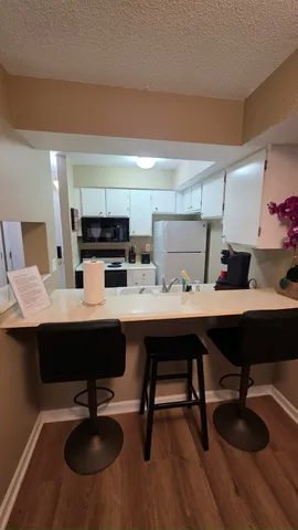 a kitchen with a sink cabinets and wooden floor