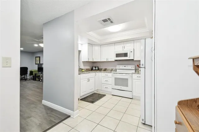 a kitchen with granite countertop a sink a stove and cabinets