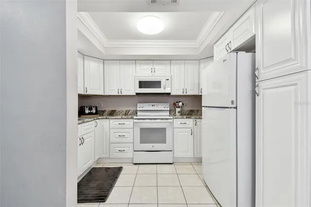 a kitchen with stainless steel appliances granite countertop white cabinets a sink and dishwasher