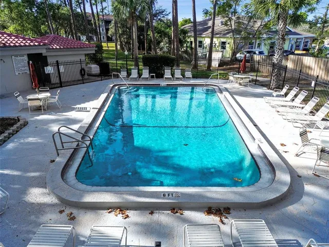 a view of swimming pool with a table and chairs under an umbrella
