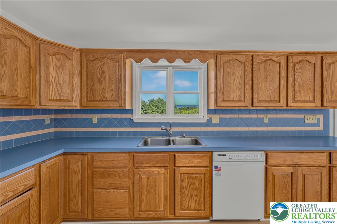 630 Clearfield Road Nazareth, PA 18064 - Photo 36 of 100 Ample wooden cabinetry and integrated appliances frame a scenic window view in this classic kitchen.