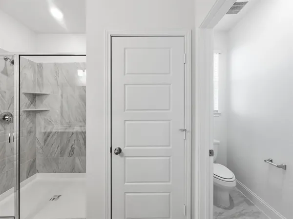 a bathroom with a shower a toilet and a sink