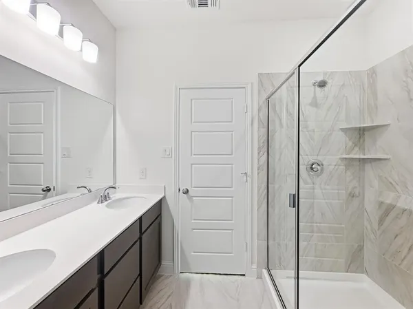 a bathroom with a shower sink and mirror