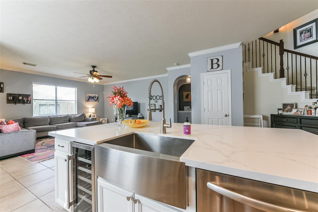a large kitchen with stainless steel appliances a sink and cabinets