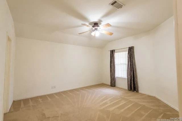 an empty room with closet and a chandelier fan