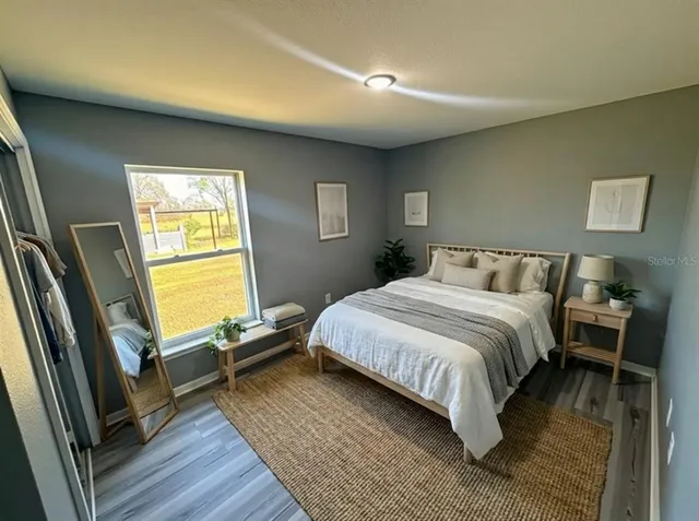 a bedroom with a bed and wooden floor