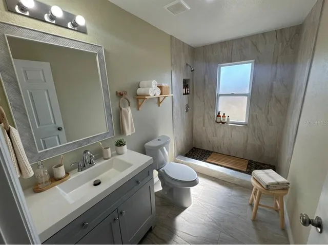 a bedroom with a bed a mirror and a potted plant