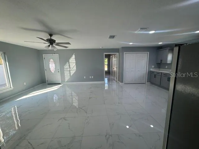 an empty room with a window and a fan