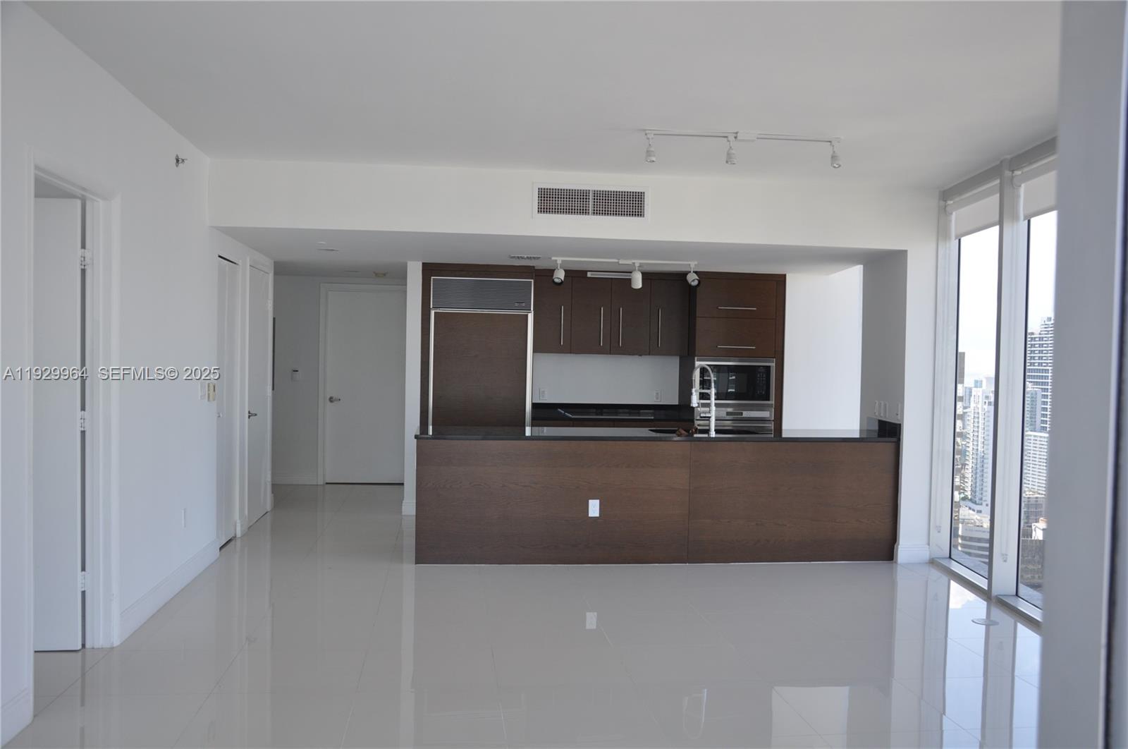 475 Brickell Avenue, Unit 4215 Miami, FL 33131 - Photo 2 of 17 a living room with stainless steel appliances kitchen island a sink and a refrigerator