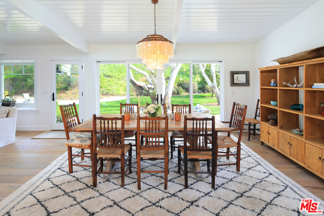 6152 Bonsall Drive Malibu, CA 90265 - Photo 12 of 26 a dining room with furniture a chandelier and wooden floor