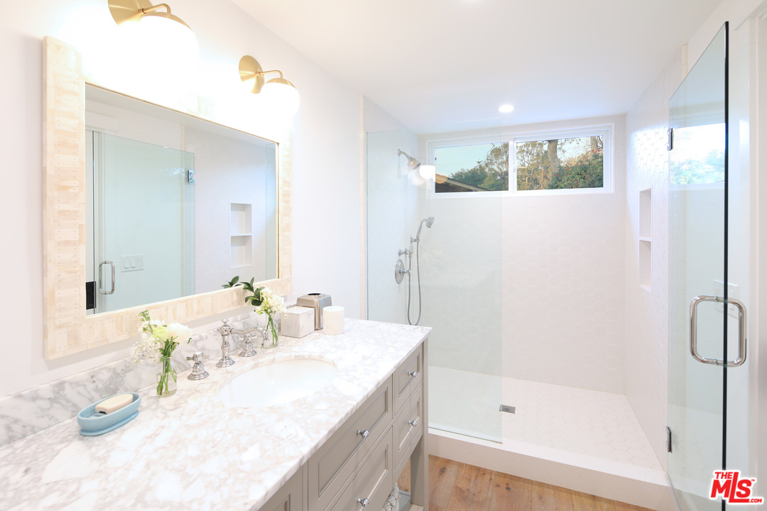 6152 Bonsall Drive Malibu, CA 90265 - Photo 18 of 26 a bathroom with a granite countertop sink a mirror and a bathtub