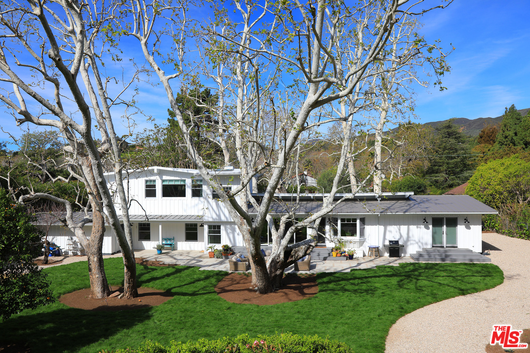 6152 Bonsall Drive Malibu, CA 90265 - Photo 22 of 26 a view of a white house with a big yard and large trees