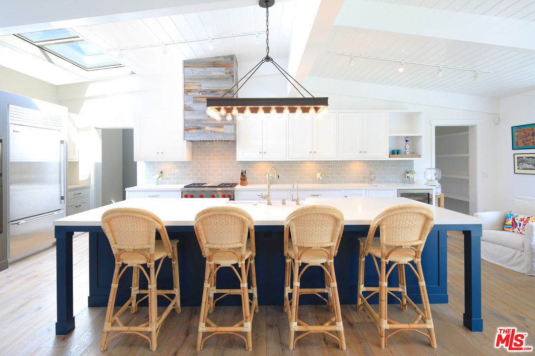 6152 Bonsall Drive Malibu, CA 90265 - Photo 5 of 26 a kitchen with granite countertop a dining table chairs and white cabinets