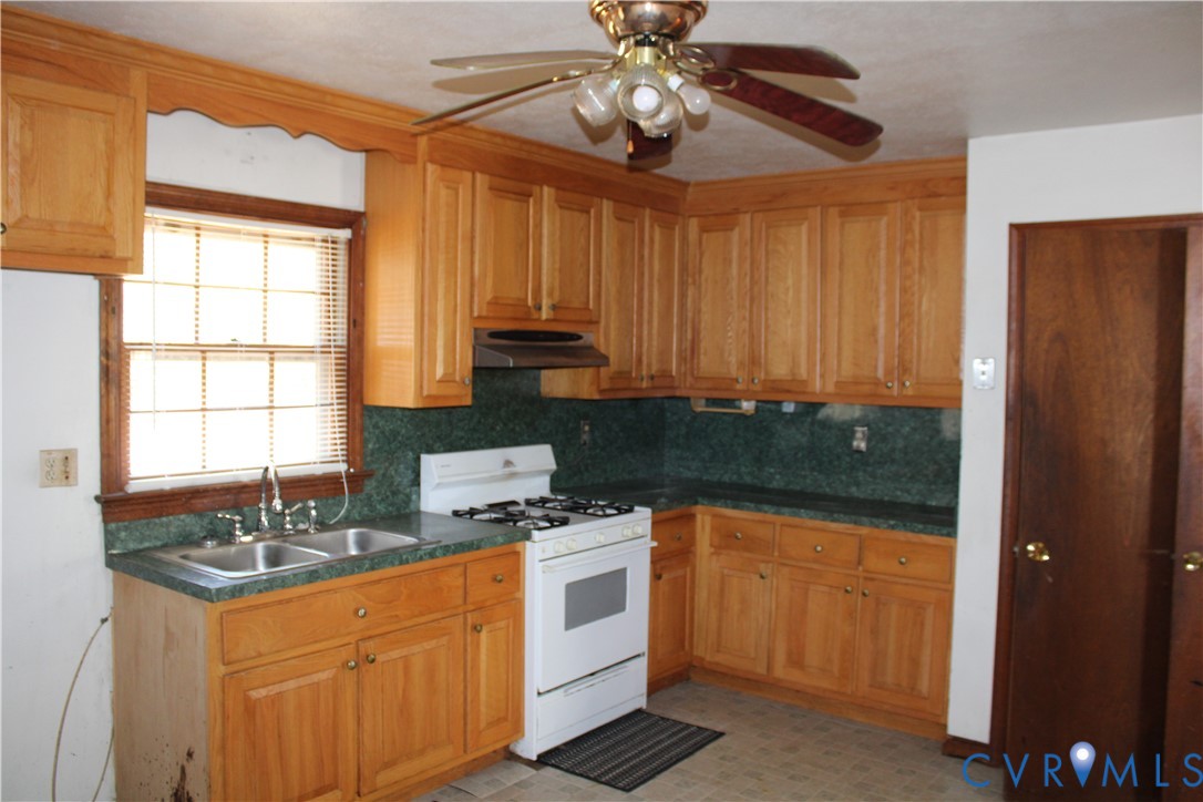7421 Adkins Road Charles City, VA 23030 - Photo 7 of 14 a kitchen with stainless steel appliances a sink a stove cabinets and a window