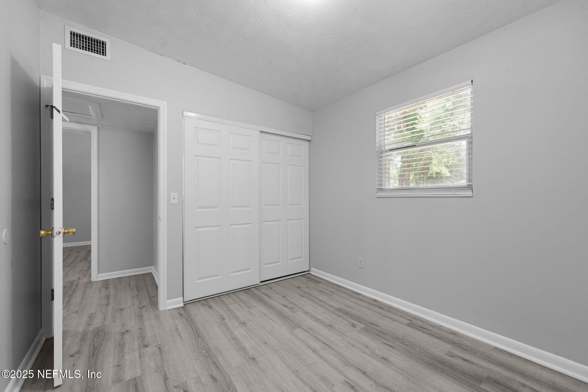 2254 Firestone Road Jacksonville, FL 32210 - Photo 13 of 20 an empty room with wooden floor and windows