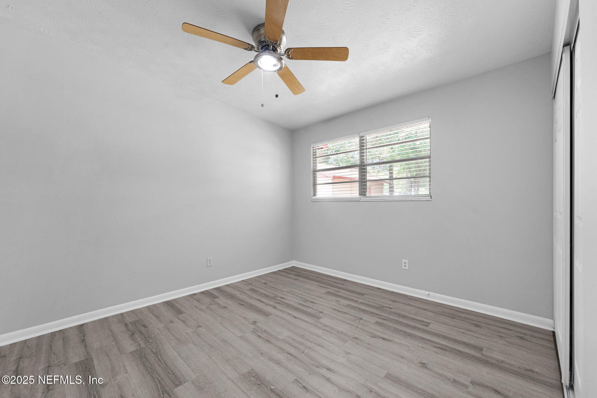 2254 Firestone Road Jacksonville, FL 32210 - Photo 14 of 20 an empty room with wooden floor and windows
