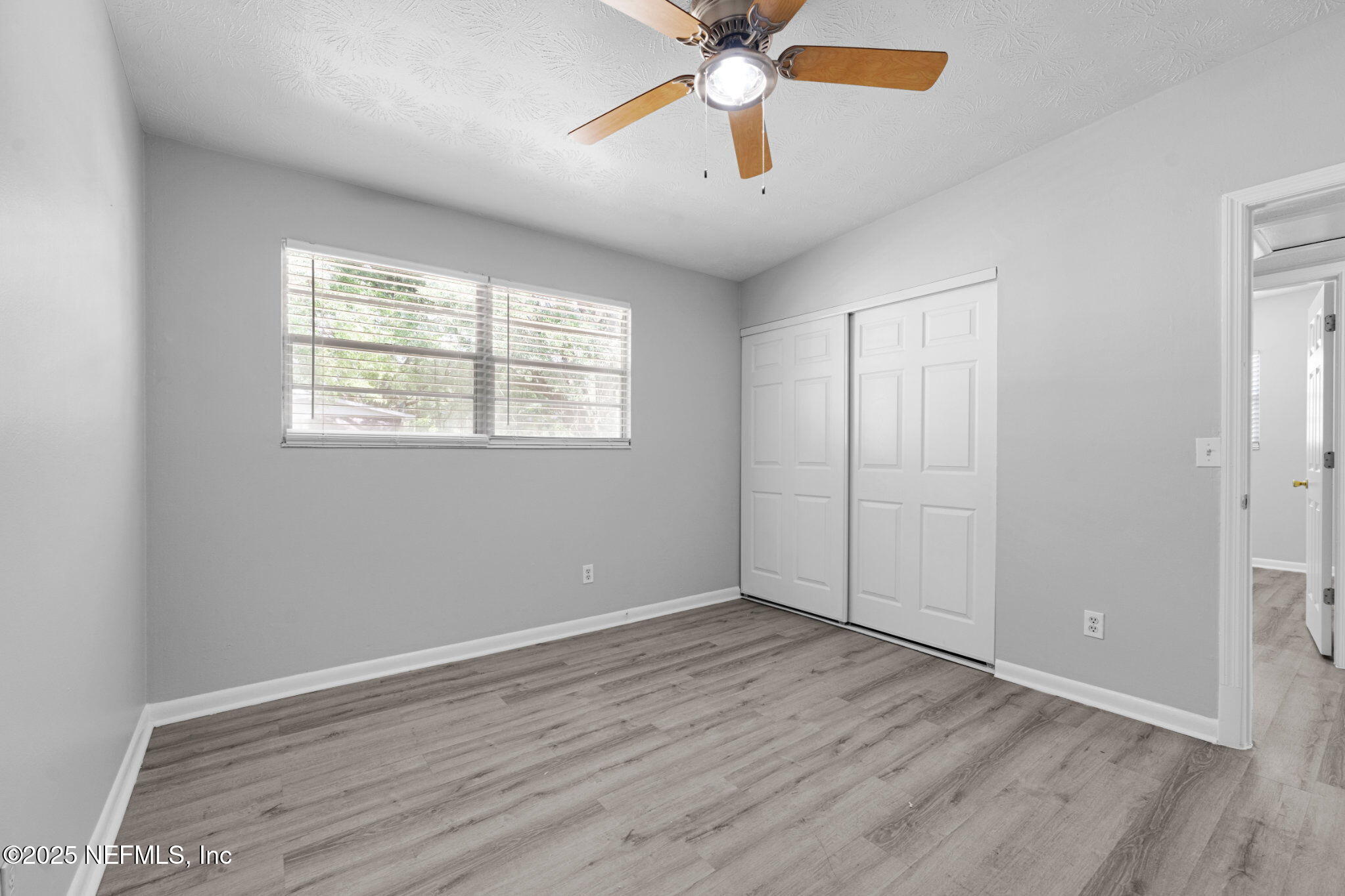 2254 Firestone Road Jacksonville, FL 32210 - Photo 15 of 20 wooden floor in an empty room with a window