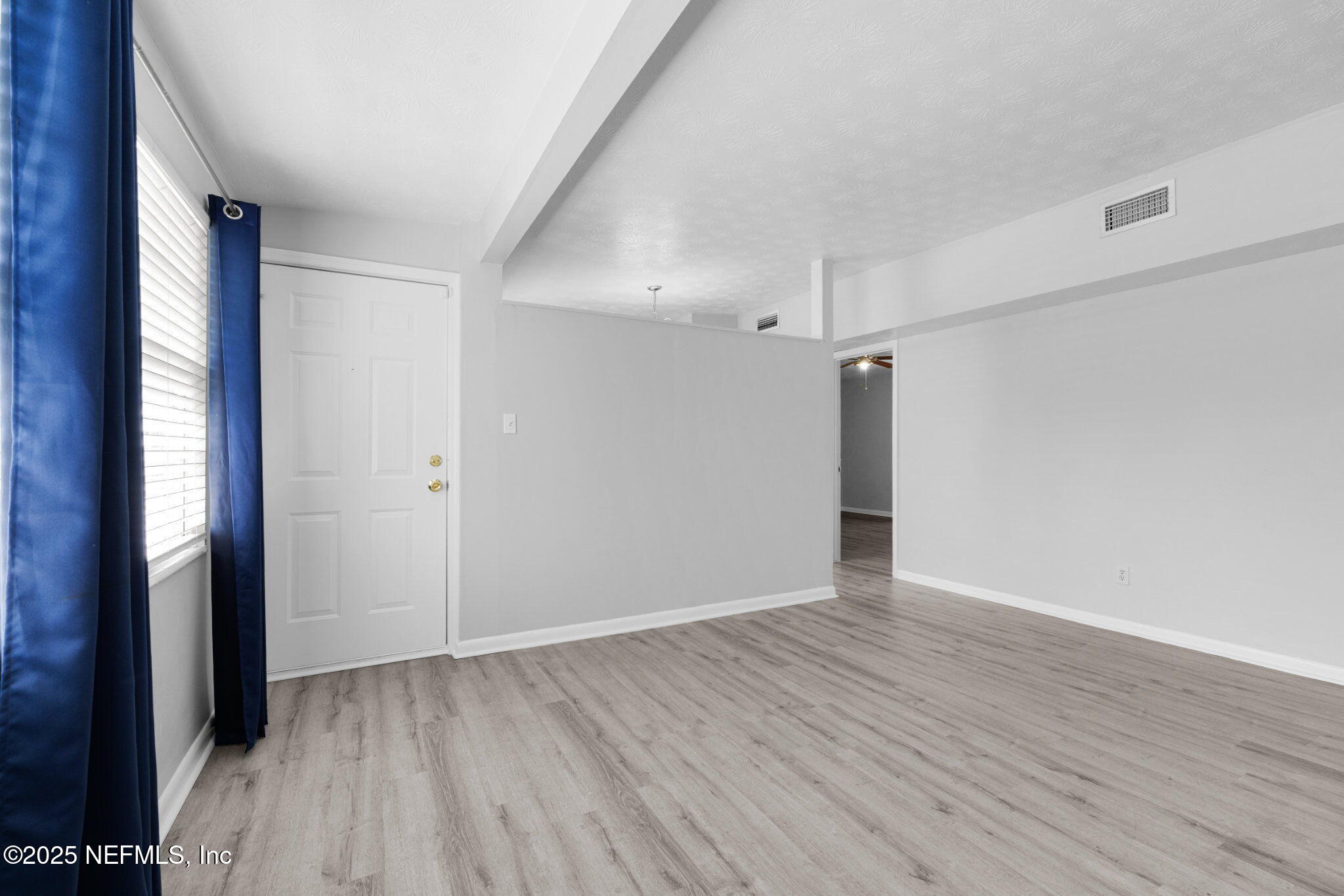 2254 Firestone Road Jacksonville, FL 32210 - Photo 3 of 20 a view of an empty room with wooden floor and a window
