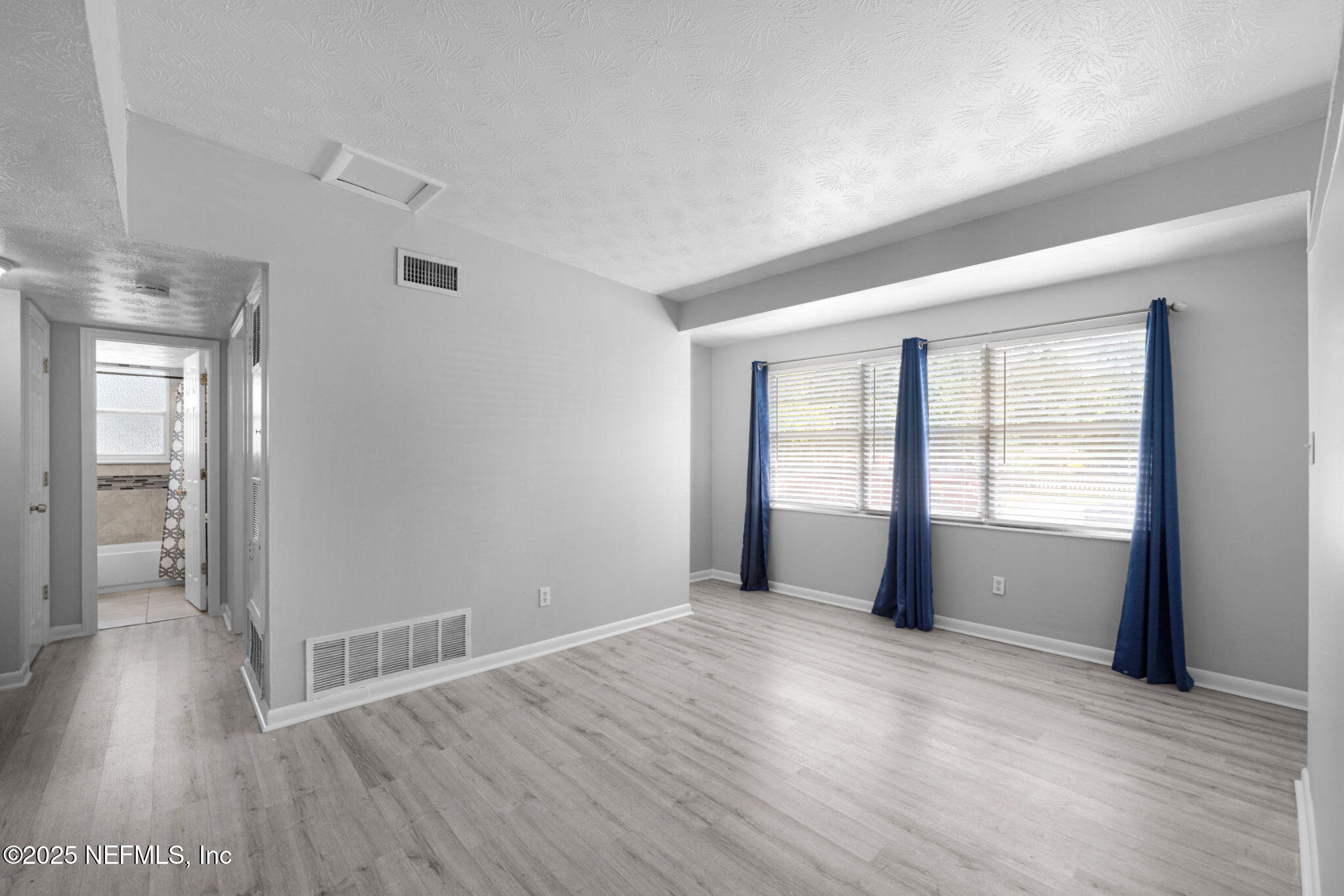 2254 Firestone Road Jacksonville, FL 32210 - Photo 5 of 20 a view of an empty room with wooden floor and a window
