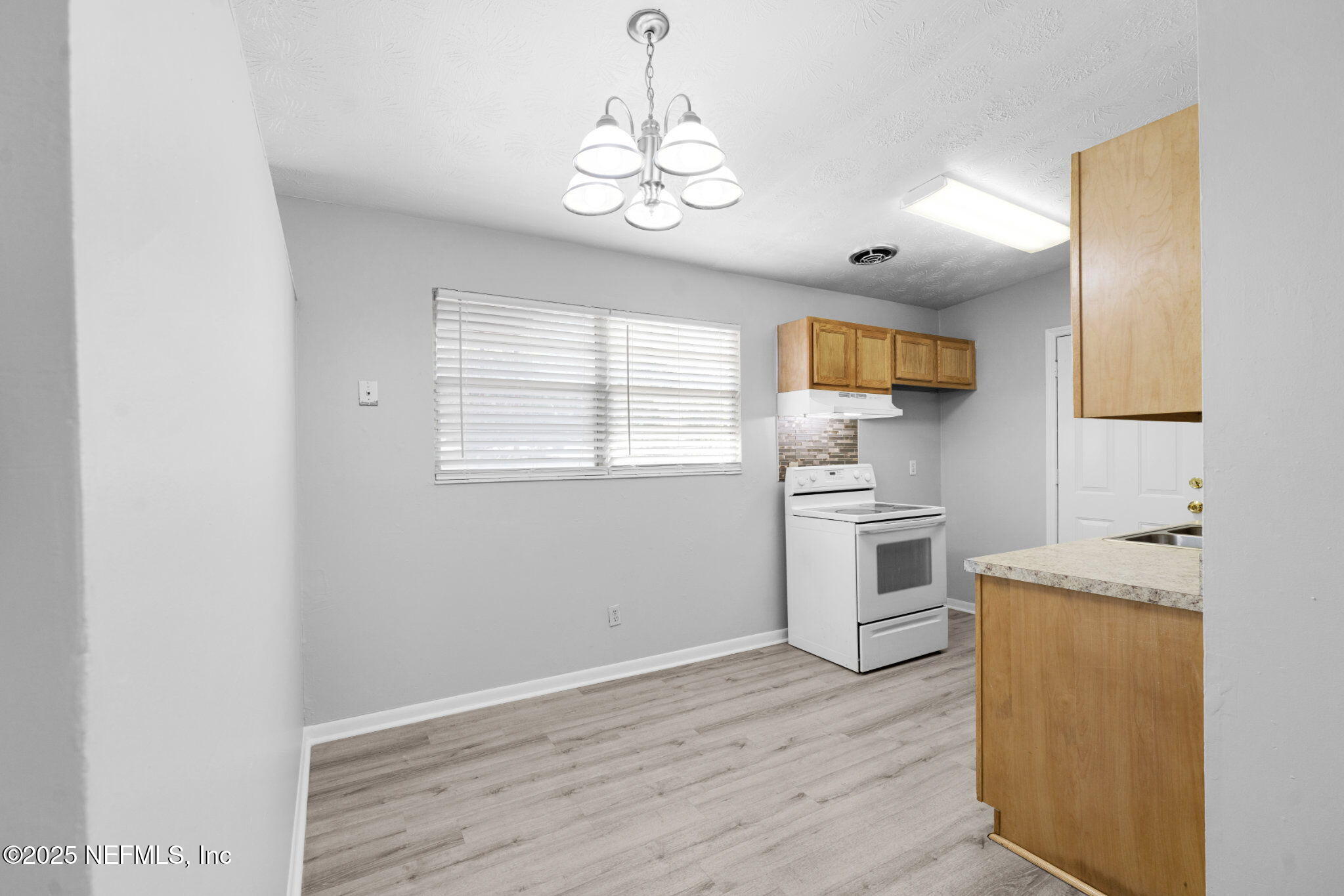 2254 Firestone Road Jacksonville, FL 32210 - Photo 6 of 20 a kitchen with a refrigerator and a stove top oven
