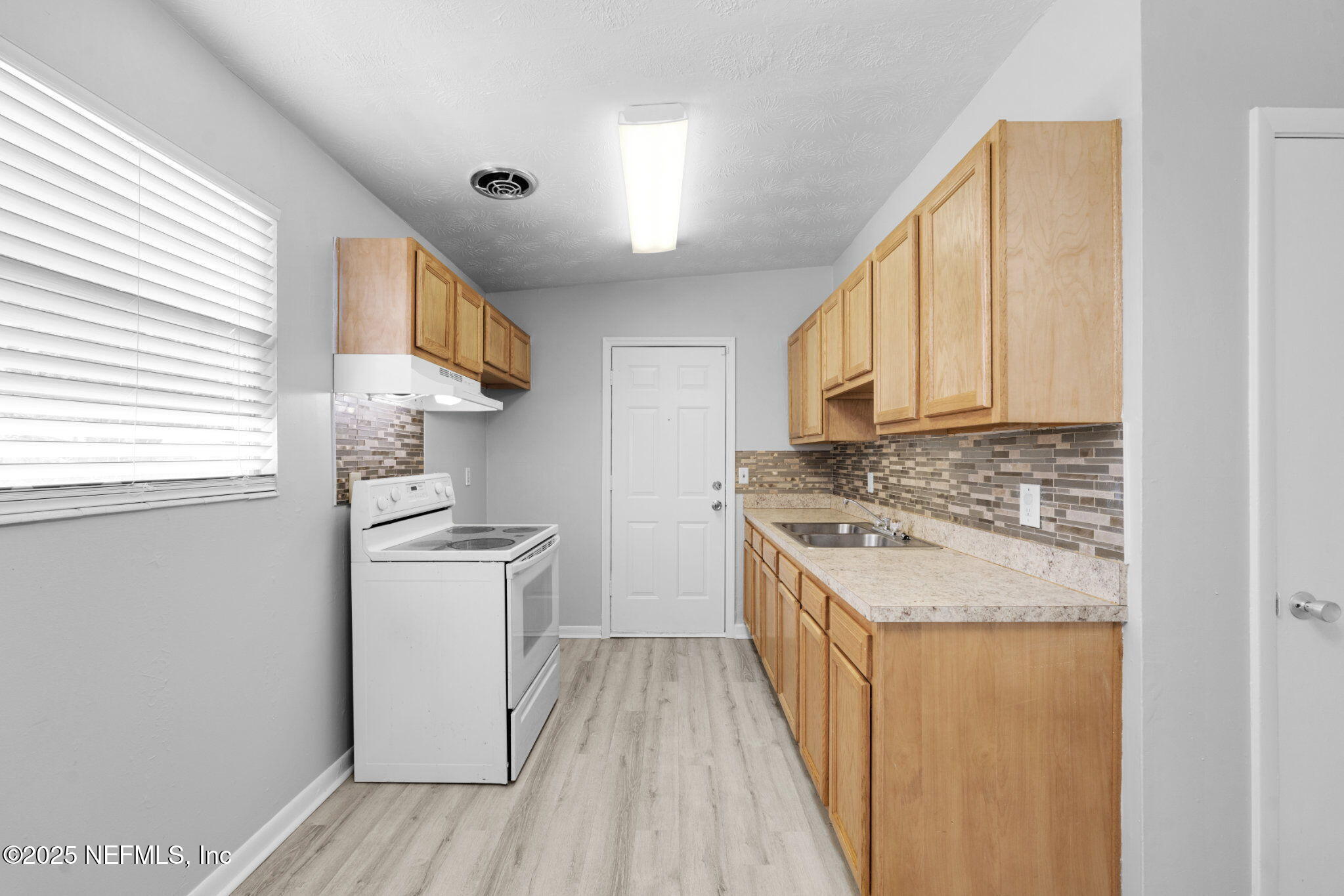 2254 Firestone Road Jacksonville, FL 32210 - Photo 7 of 20 a kitchen with a stove a sink and a refrigerator