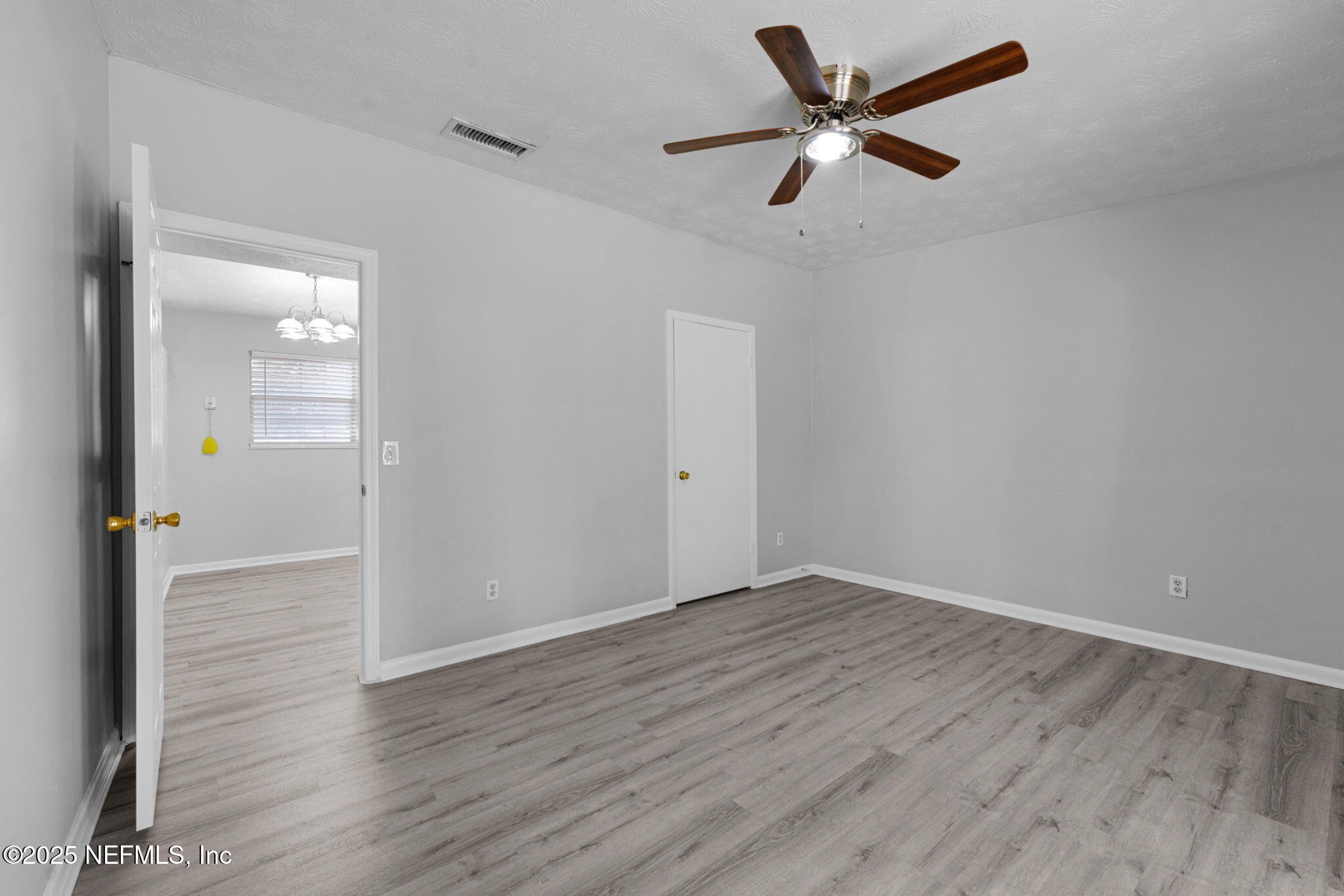 2254 Firestone Road Jacksonville, FL 32210 - Photo 9 of 20 an empty room with wooden floor and a ceiling fan