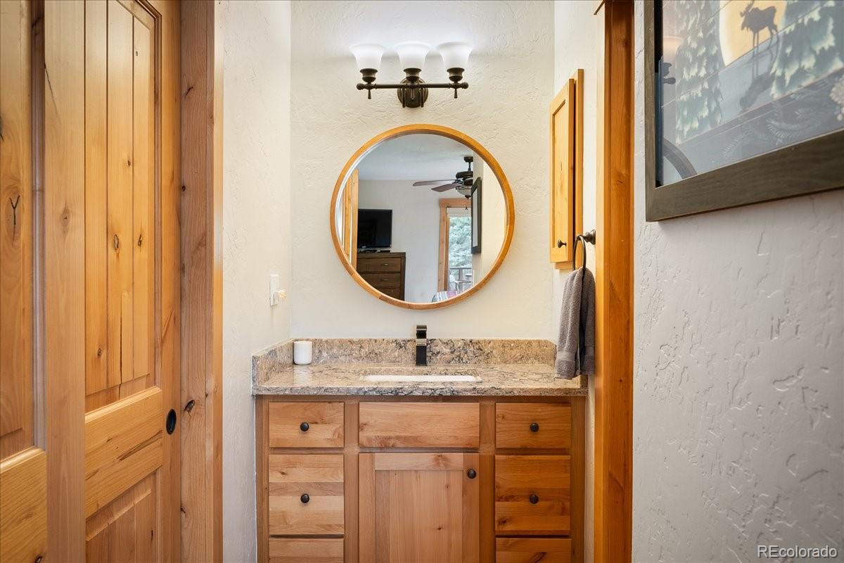 605 Lake Front Road, Unit 8 Grand Lake, CO 80447 - Photo 19 of 30 a bathroom with a granite countertop sink a mirror and a vanity