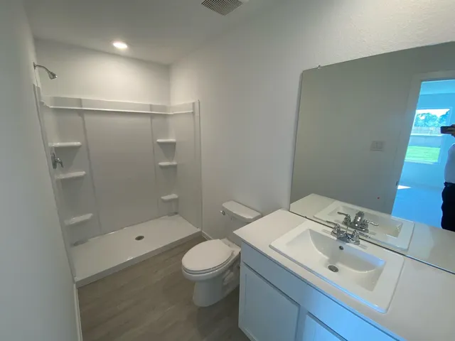 a bathroom with a sink and mirror with toilet