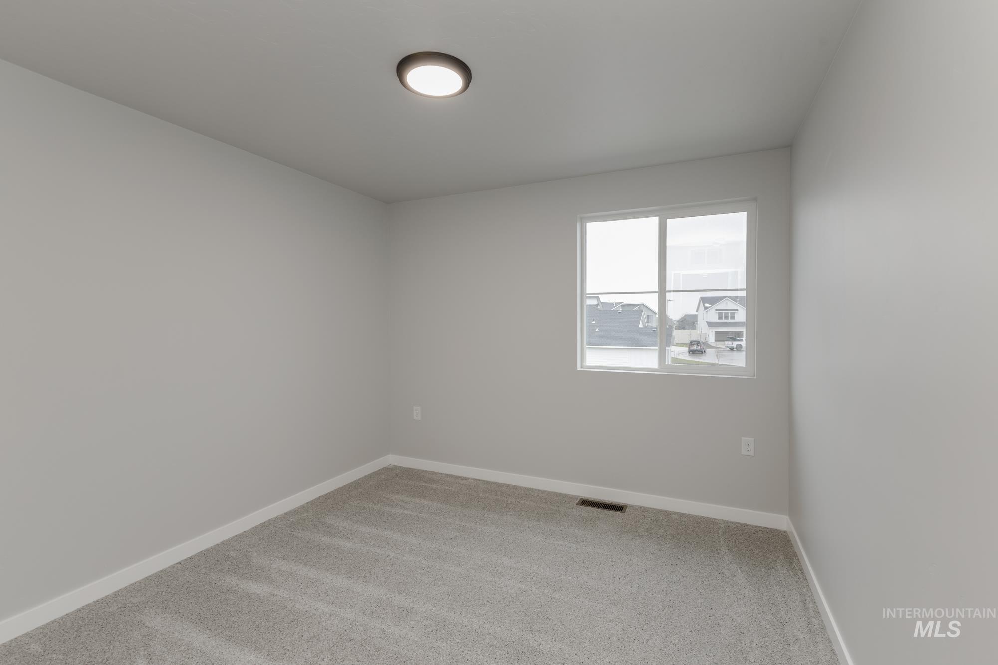 13743 Judson Street Caldwell, ID 83607 - Photo 14 of 23 Empty room featuring light carpet and baseboards