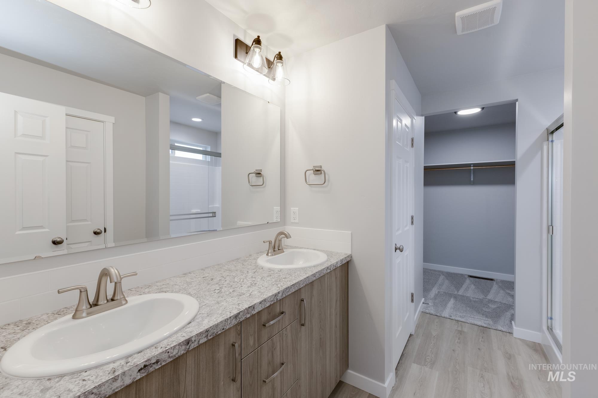 13743 Judson Street Caldwell, ID 83607 - Photo 21 of 23 Bathroom with a shower stall, a spacious closet, double vanity, and light wood-style floors