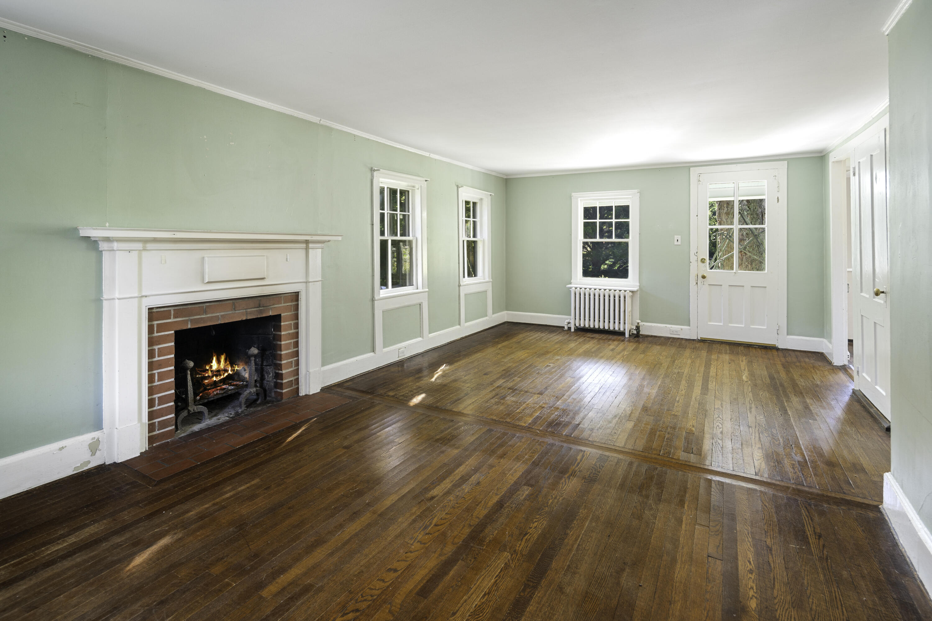 40 Ogden Road New Canaan, CT 06840 - Photo 7 of 35 a view of an empty room with wooden floor fireplace and a window