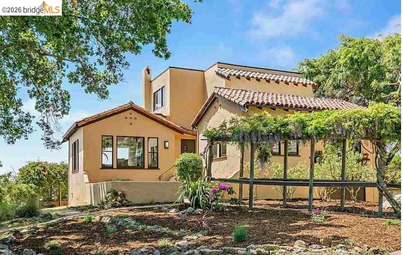View of front of home with stucco siding and a tiled roof