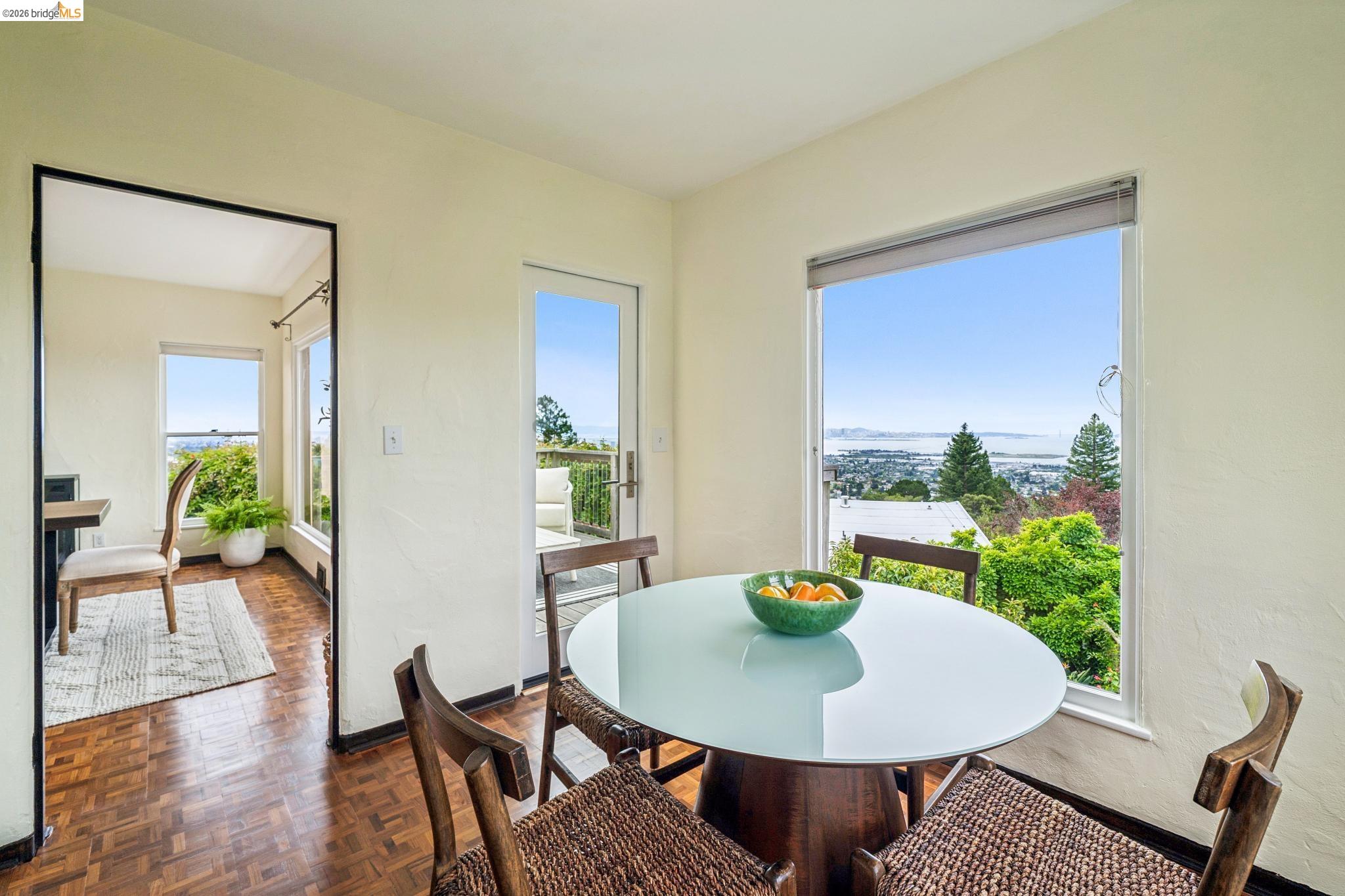 784 Cragmont Avenue Berkeley, CA 94708 - Photo 30 of 64 Dining area featuring wood-finish parquet flooring, a large picture window, and a glass-paneled door opening to an outdoor deck