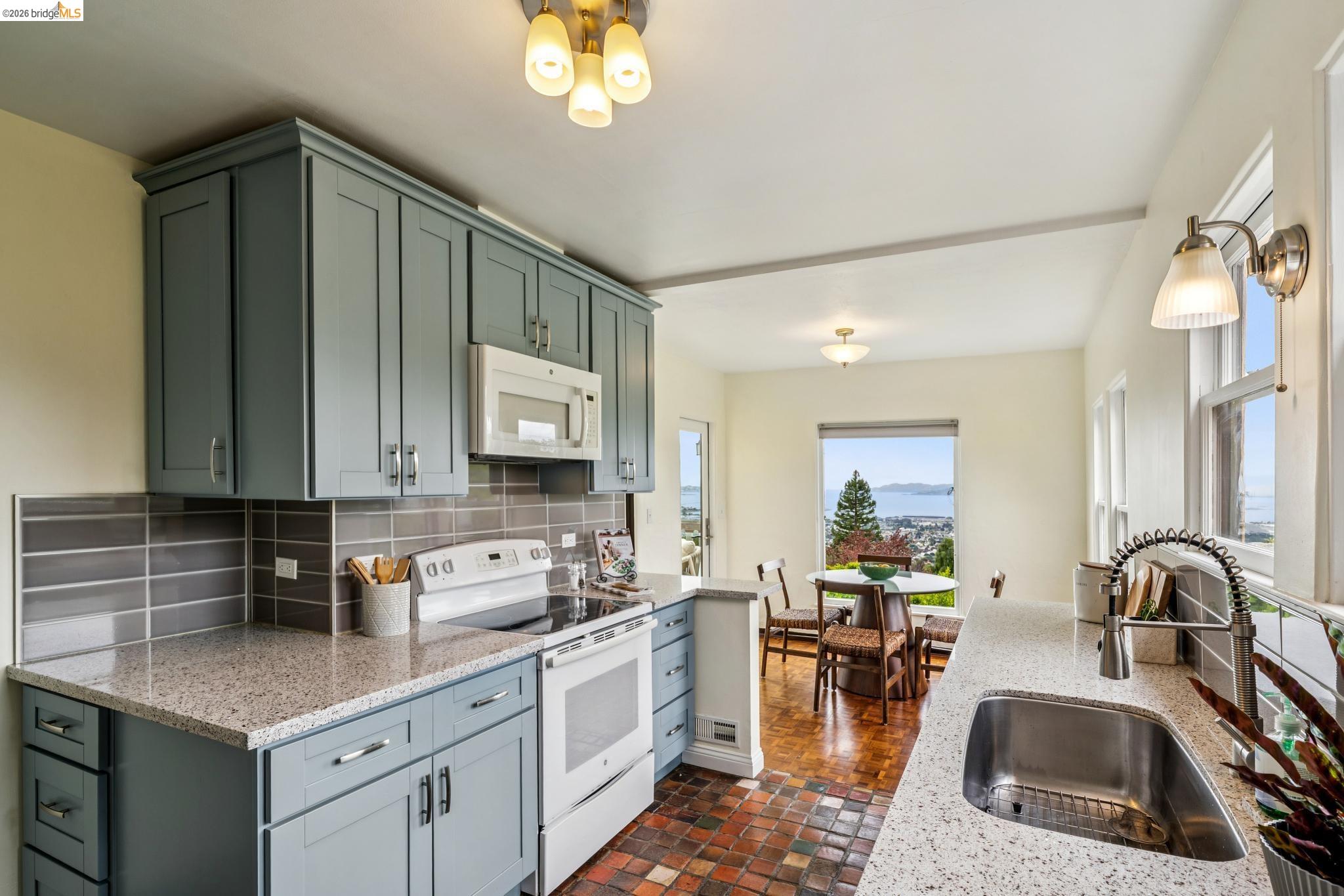 784 Cragmont Avenue Berkeley, CA 94708 - Photo 32 of 64 Kitchen featuring light blue cabinetry, speckled countertops, stainless steel sink with a gooseneck faucet, and an integrated microwave