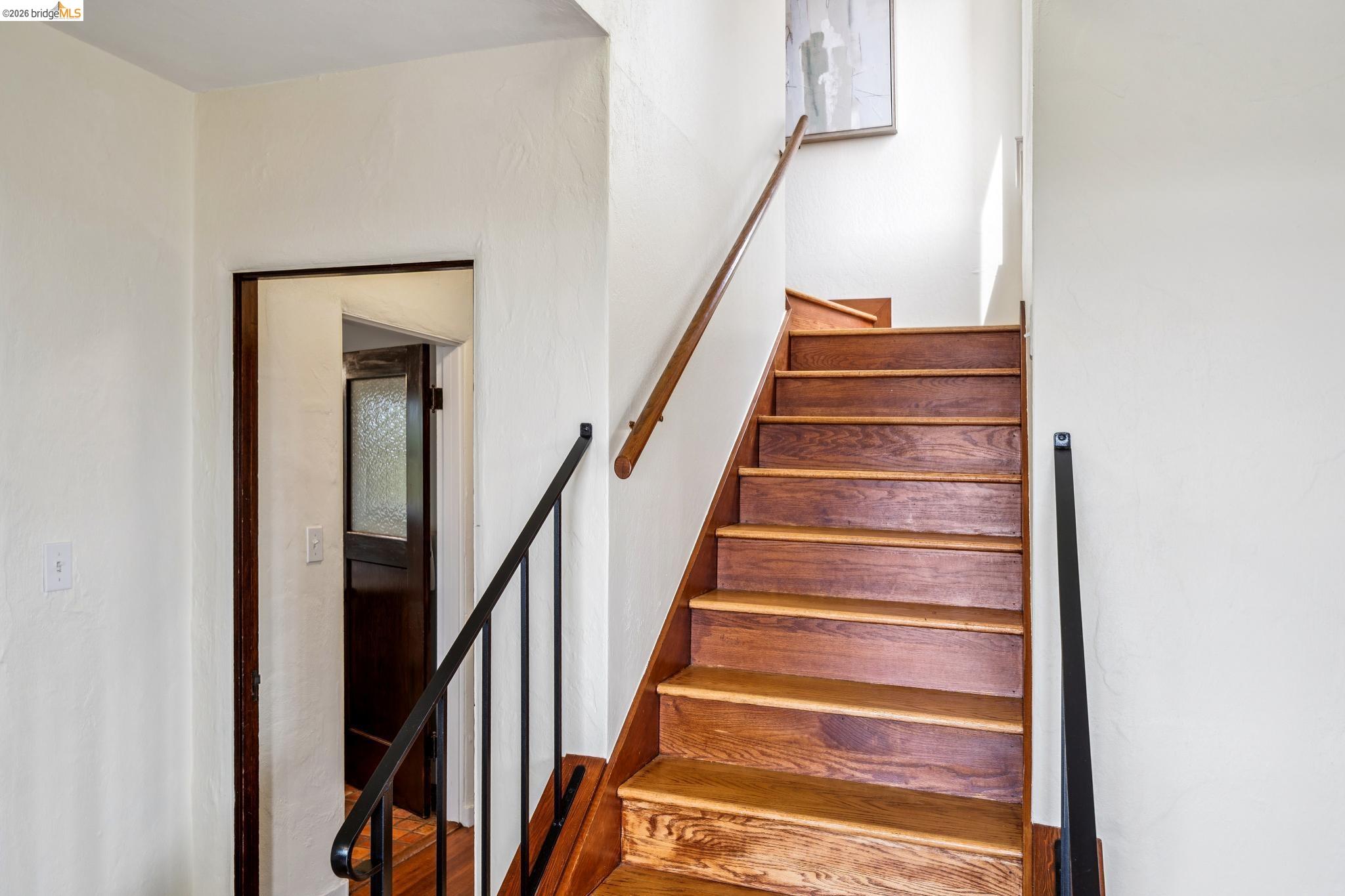 784 Cragmont Avenue Berkeley, CA 94708 - Photo 47 of 64 Staircase featuring wood treads, a wood handrail, and black iron balusters