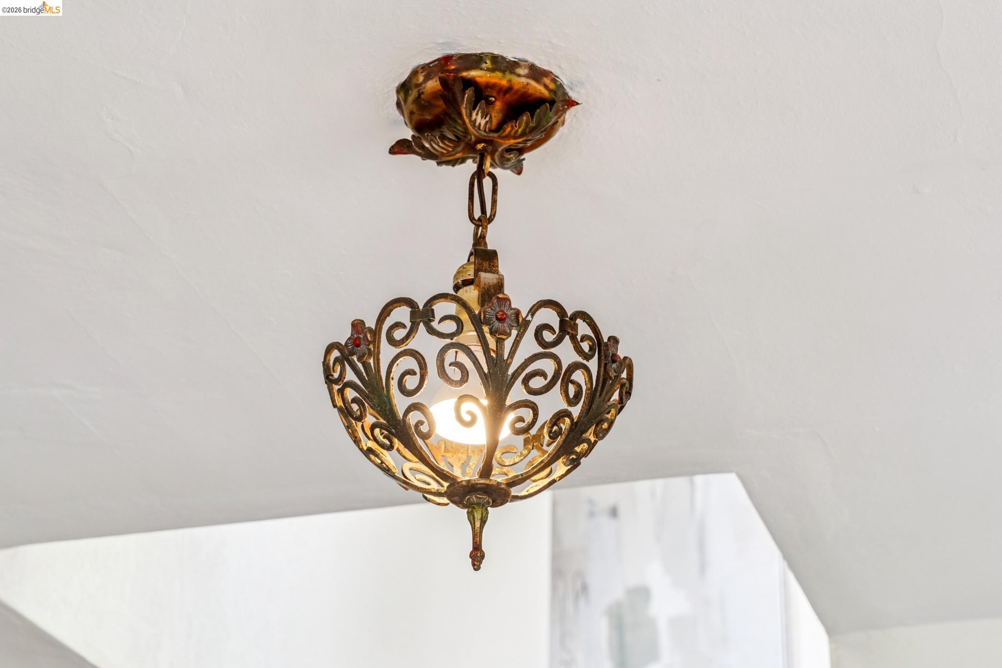 784 Cragmont Avenue Berkeley, CA 94708 - Photo 48 of 64 Ornate semi-flush mount light fixture with a decorative metal filigree frame and a central exposed bulb