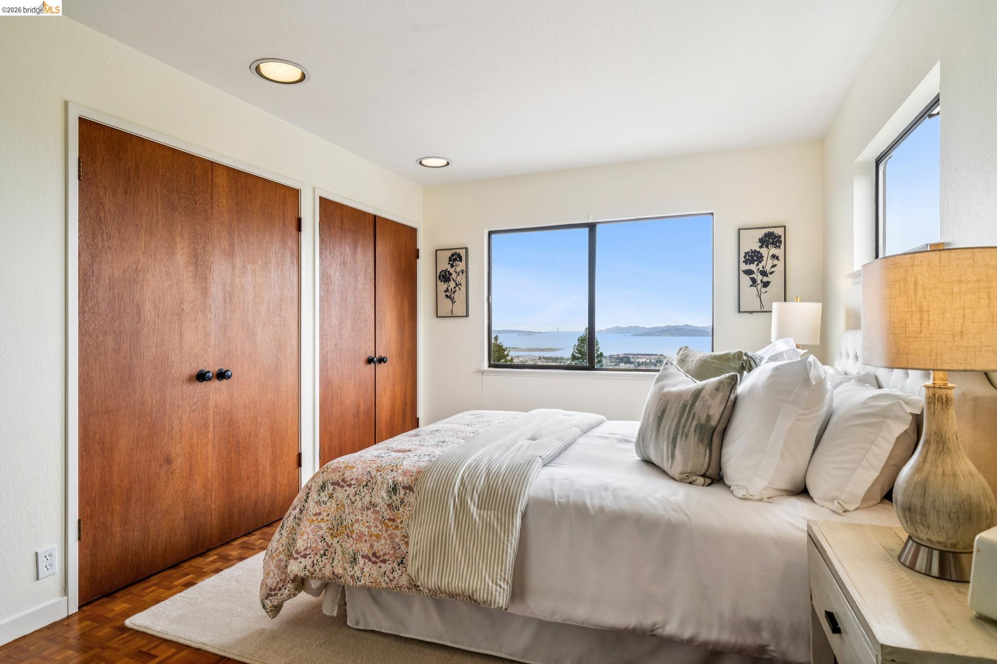784 Cragmont Avenue Berkeley, CA 94708 - Photo 50 of 64 Bedroom featuring expansive window, recessed lighting, wood-finish flooring, and built-in closet doors