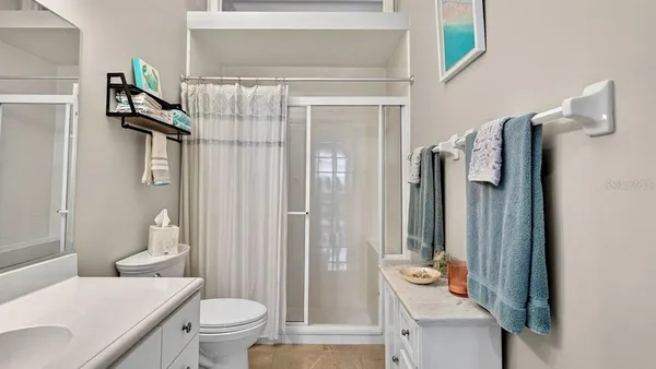 a kitchen with stainless steel appliances kitchen island granite countertop a dining table chairs and a refrigerator