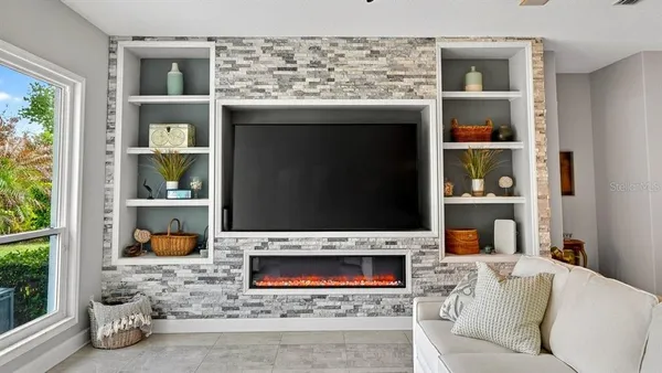 a living room with furniture potted plant and kitchen view