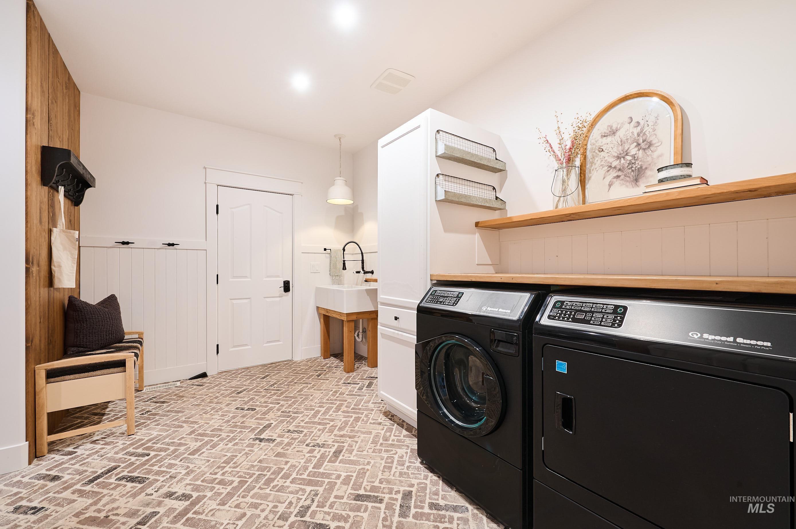 3931 North Triple Ridge Place Eagle, ID 83616 - Photo 27 of 45 Washroom with brick flooring, separate washer and dryer, and wood walls
