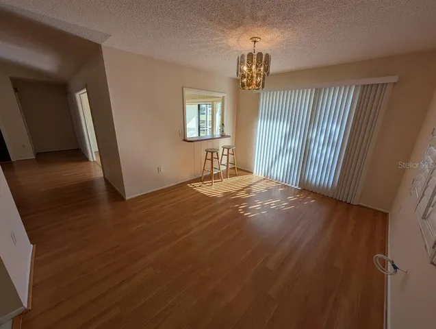 a view of empty room with wooden floor and window
