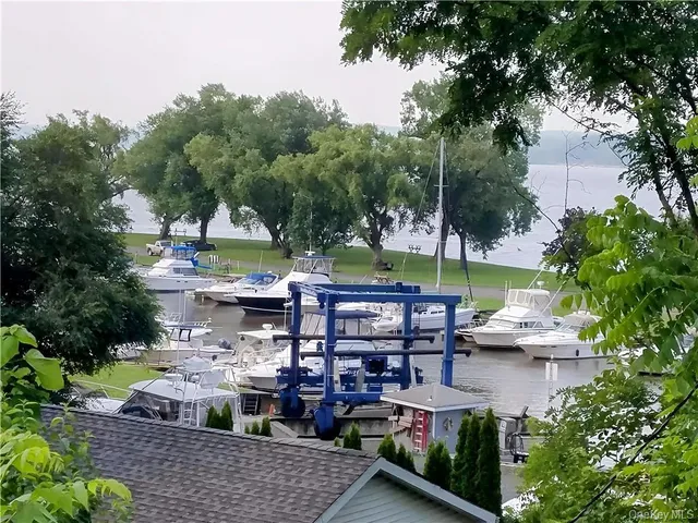 a view of a patio with table and chairs potted plants and large tree