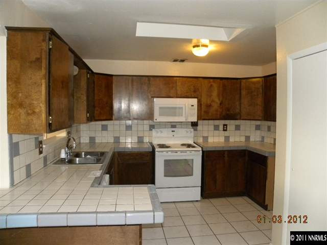 8585 Aquifer Way Reno, NV 89506 - Photo 4 of 12 a kitchen with a sink a stove and cabinets