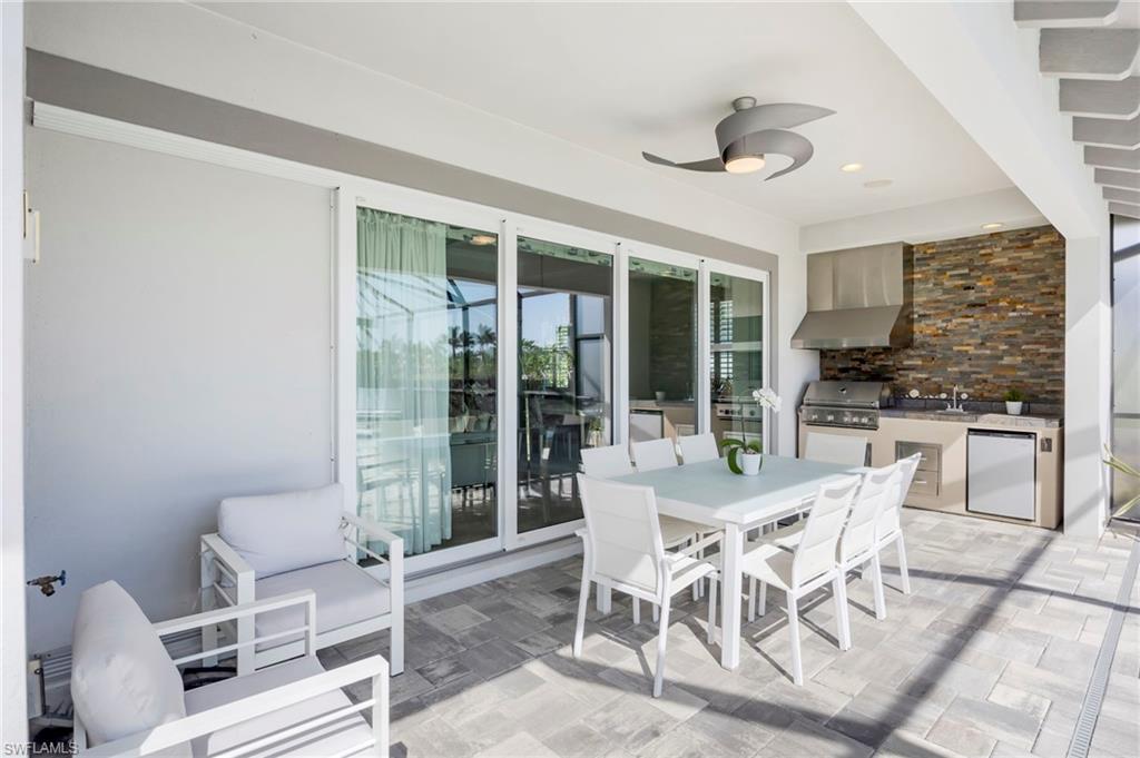 6466 Warwick Avenue Naples, FL 34113 - Photo 21 of 43 a view of a dining room with furniture large windows and kitchen view