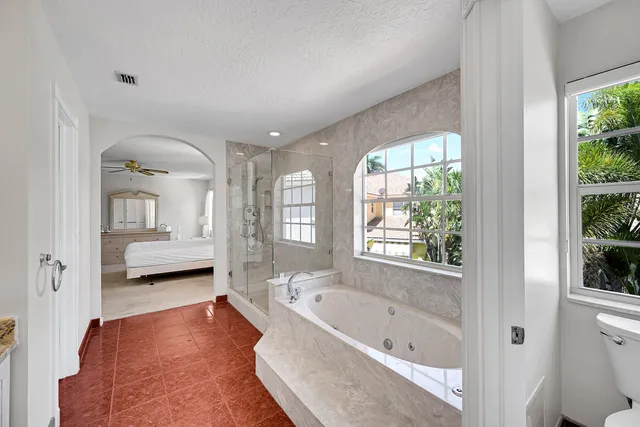 a bathroom with a granite countertop sink toilet a mirror and shower